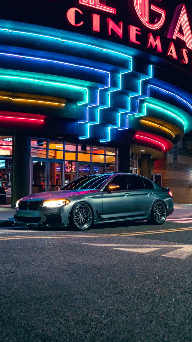 BMW sedan under neon lights